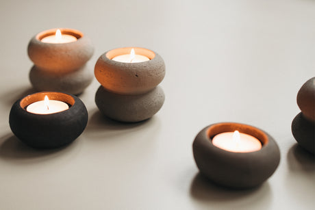 Taupe waxinelichthouder met brandend waxinelicht in Japandi interieur